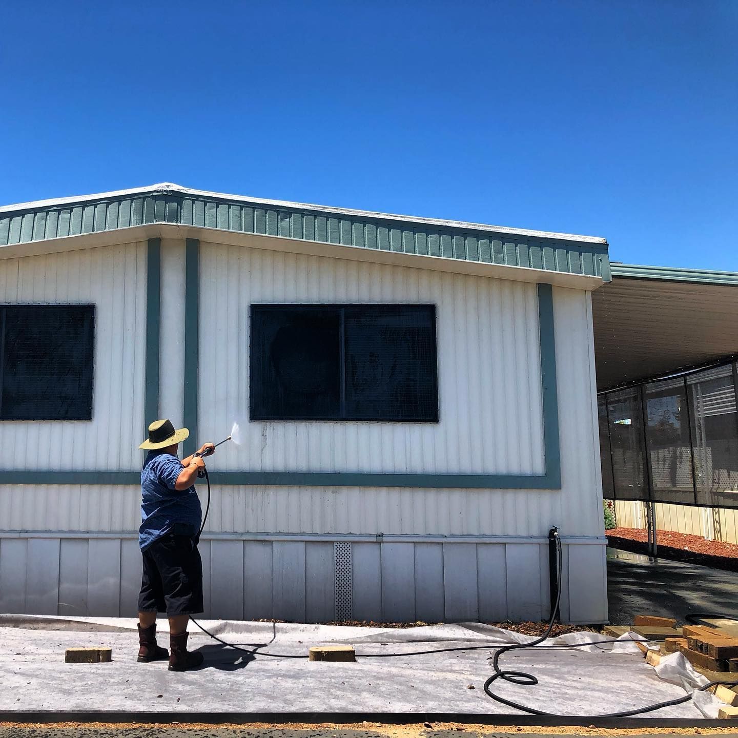 a man in a hat is spraying water on a building
