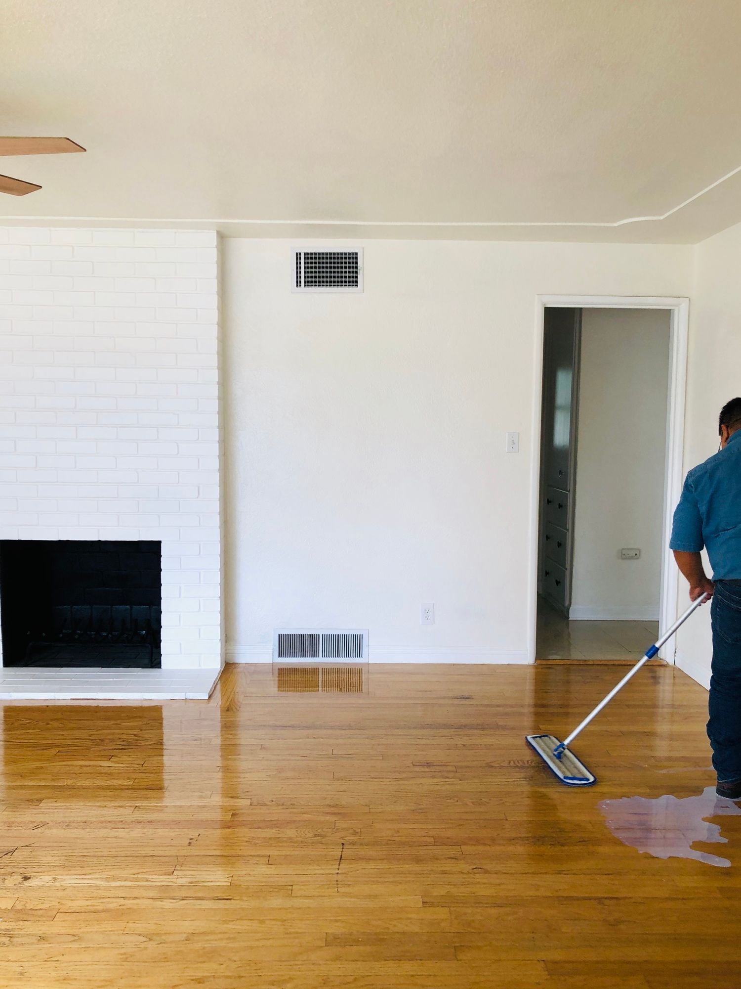 a man is mopping the floor in an empty living room