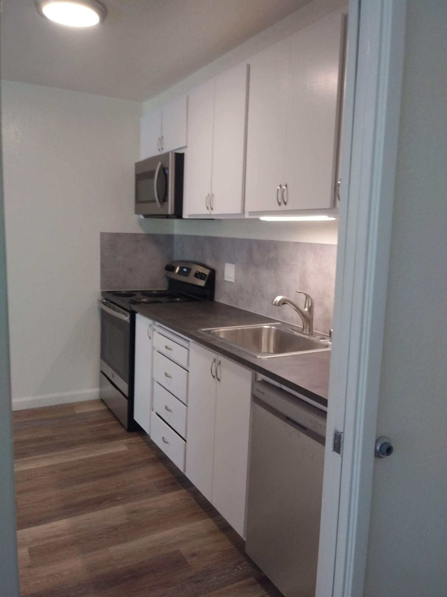 a kitchen with white cabinets and stainless steel appliances