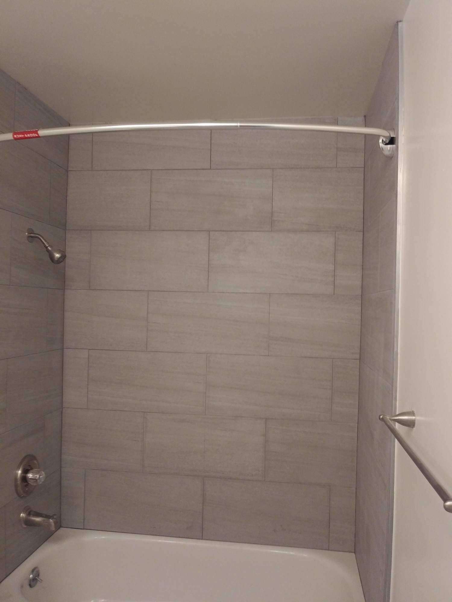 a bathroom with a bathtub , shower , and towel rack .