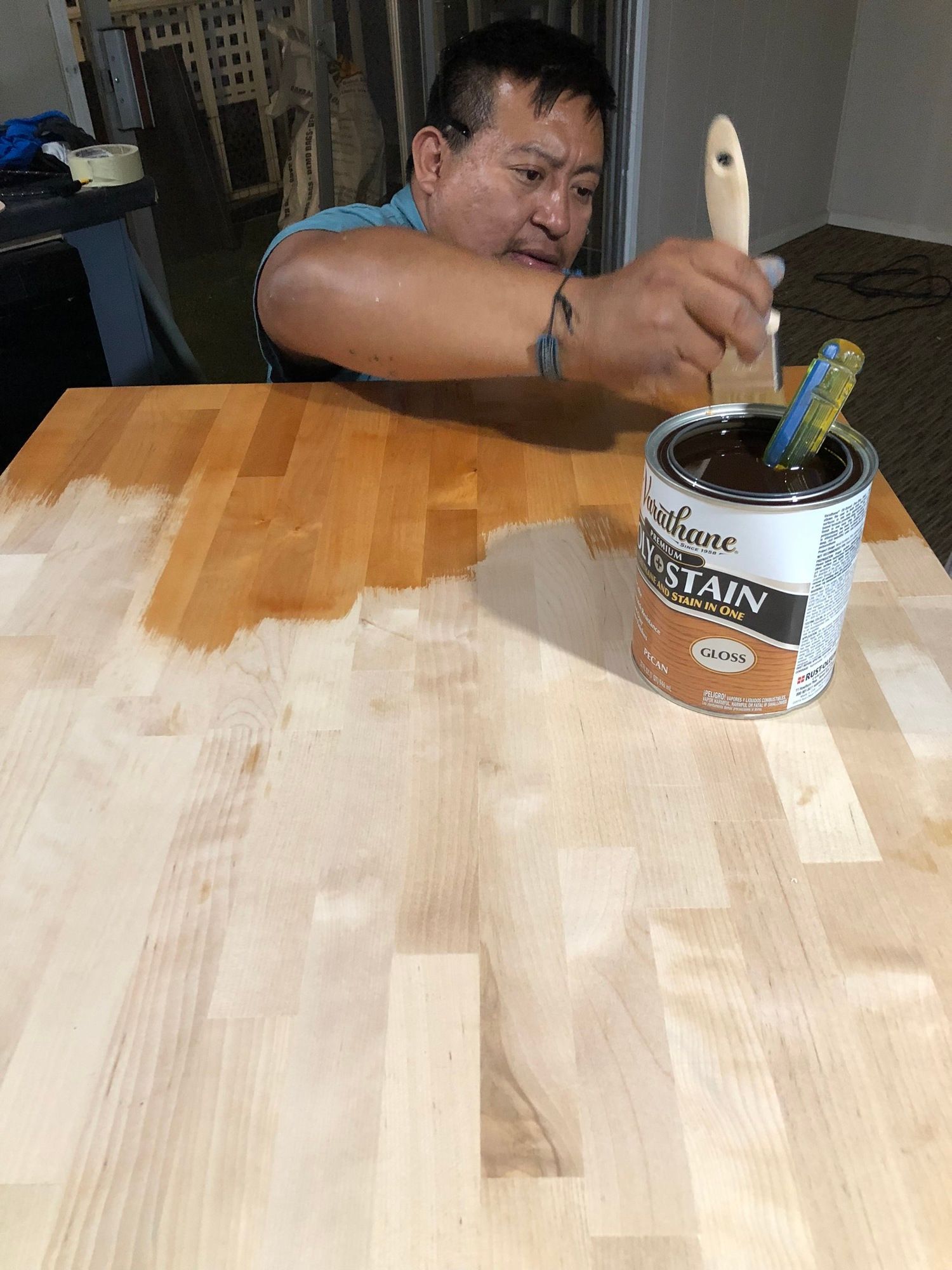 a man is painting a wooden table with a brush .