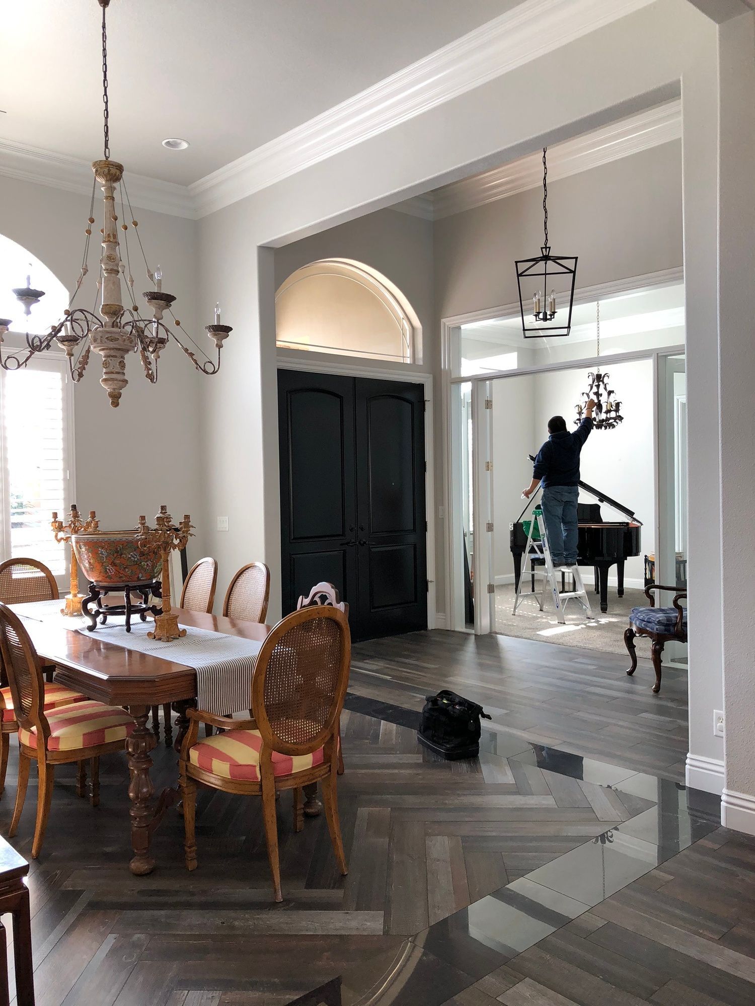 a man is standing in a living room with a piano and a table .