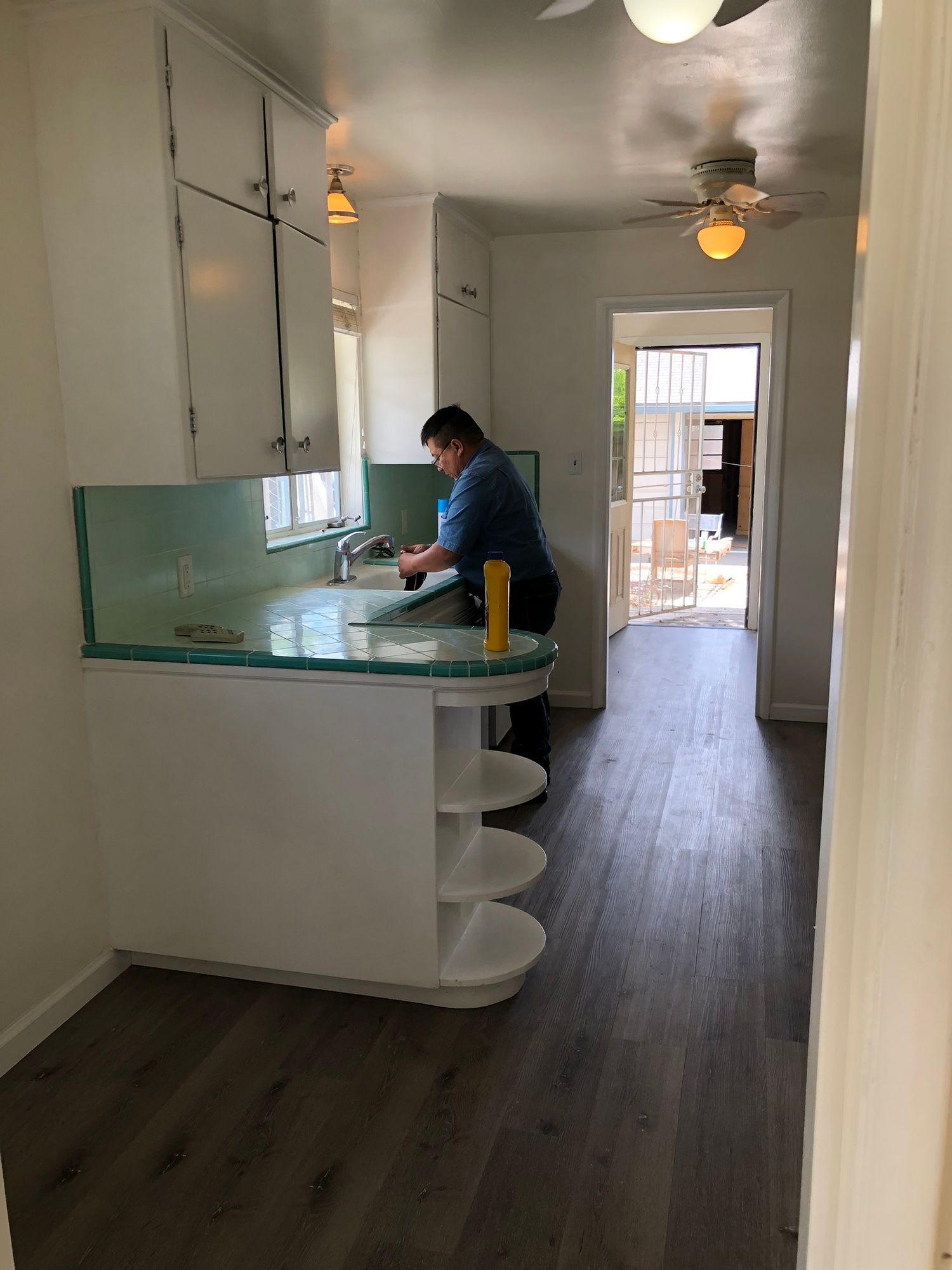 a man is standing in a kitchen working on a counter .