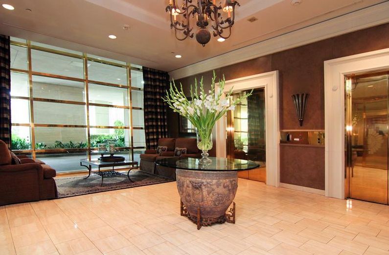 A lobby with a glass table and a vase of flowers