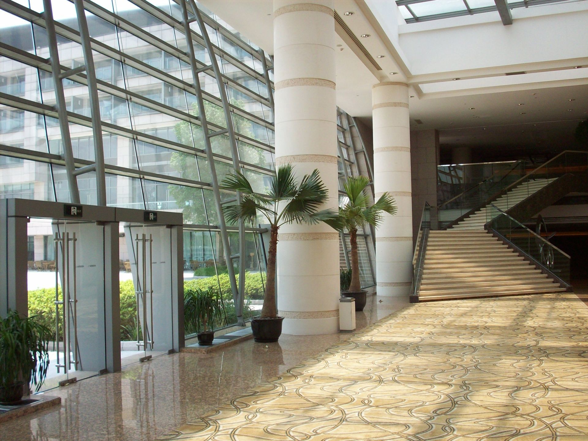 A large lobby with a staircase and lots of windows