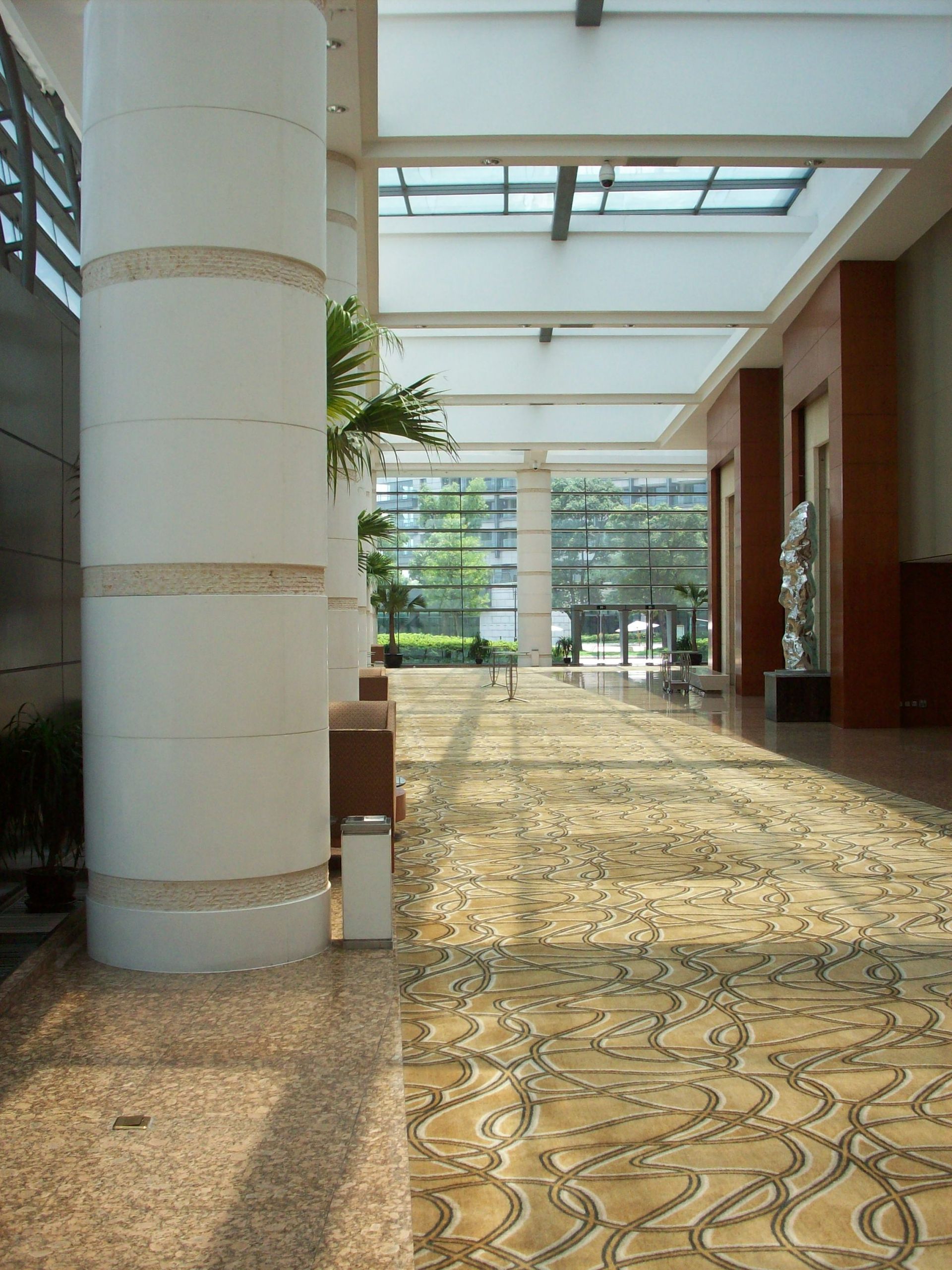 A long hallway in a building with a ceiling fan