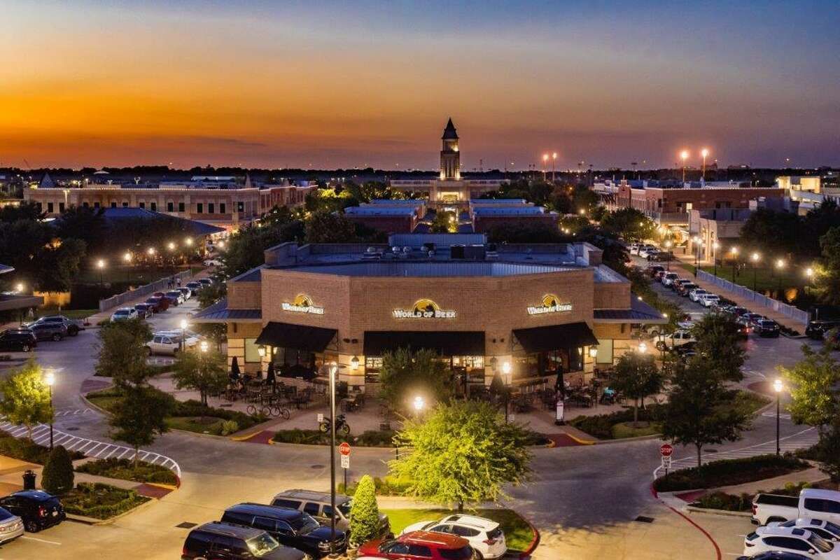 An aerial view of a city at night with cars parked in front of a building.