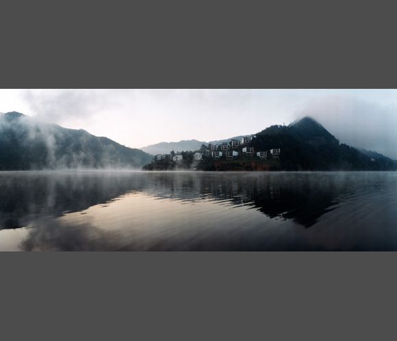 A foggy lake with mountains in the background