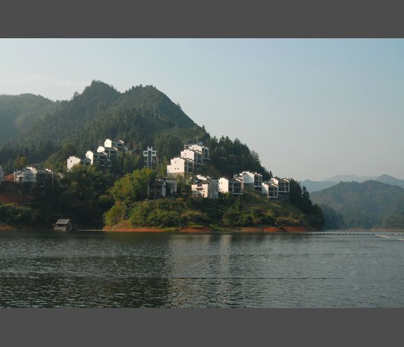 A small island in the middle of a lake with houses on it