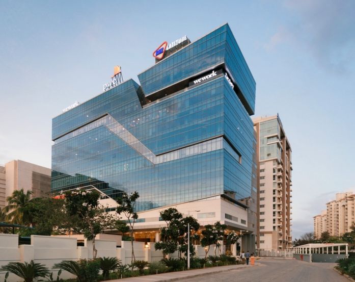 A large building with a lot of windows is surrounded by trees.