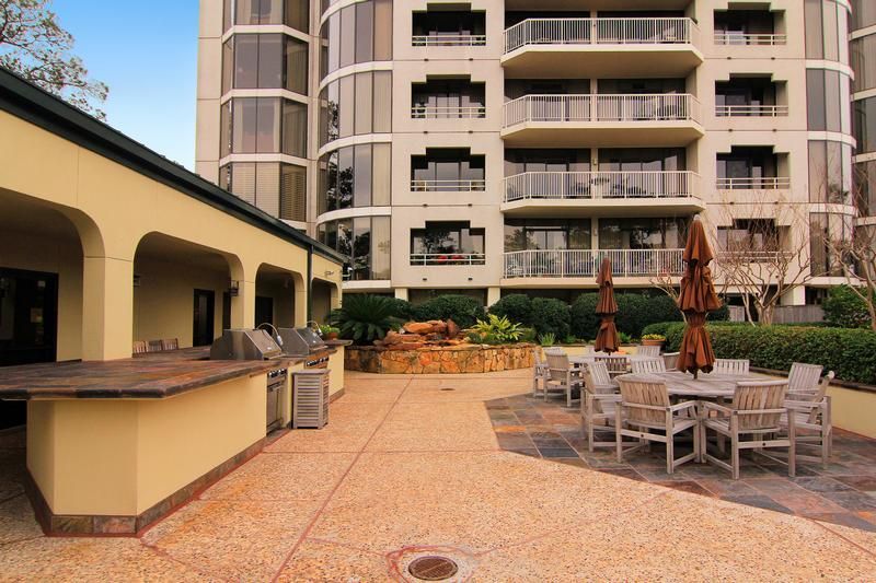 A large building with tables and chairs in front of it
