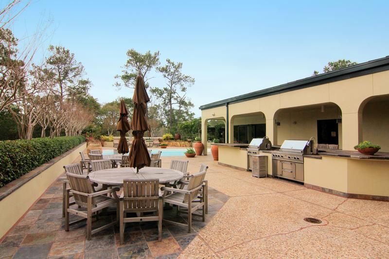 A patio area with a table and chairs and umbrellas
