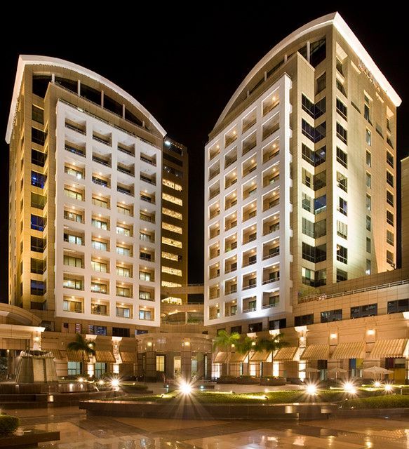 Two very tall buildings are lit up at night