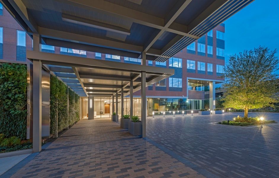 A large building with a covered walkway leading to it at night.