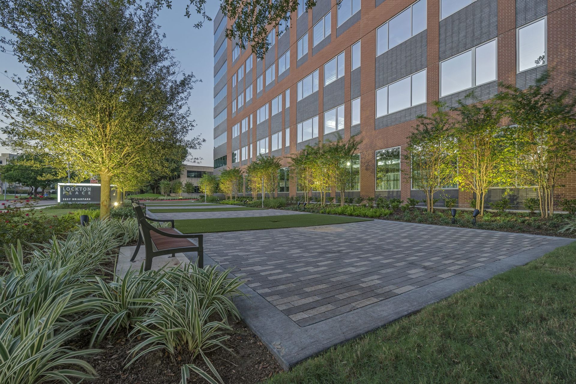 A large brick building with a bench in front of it.