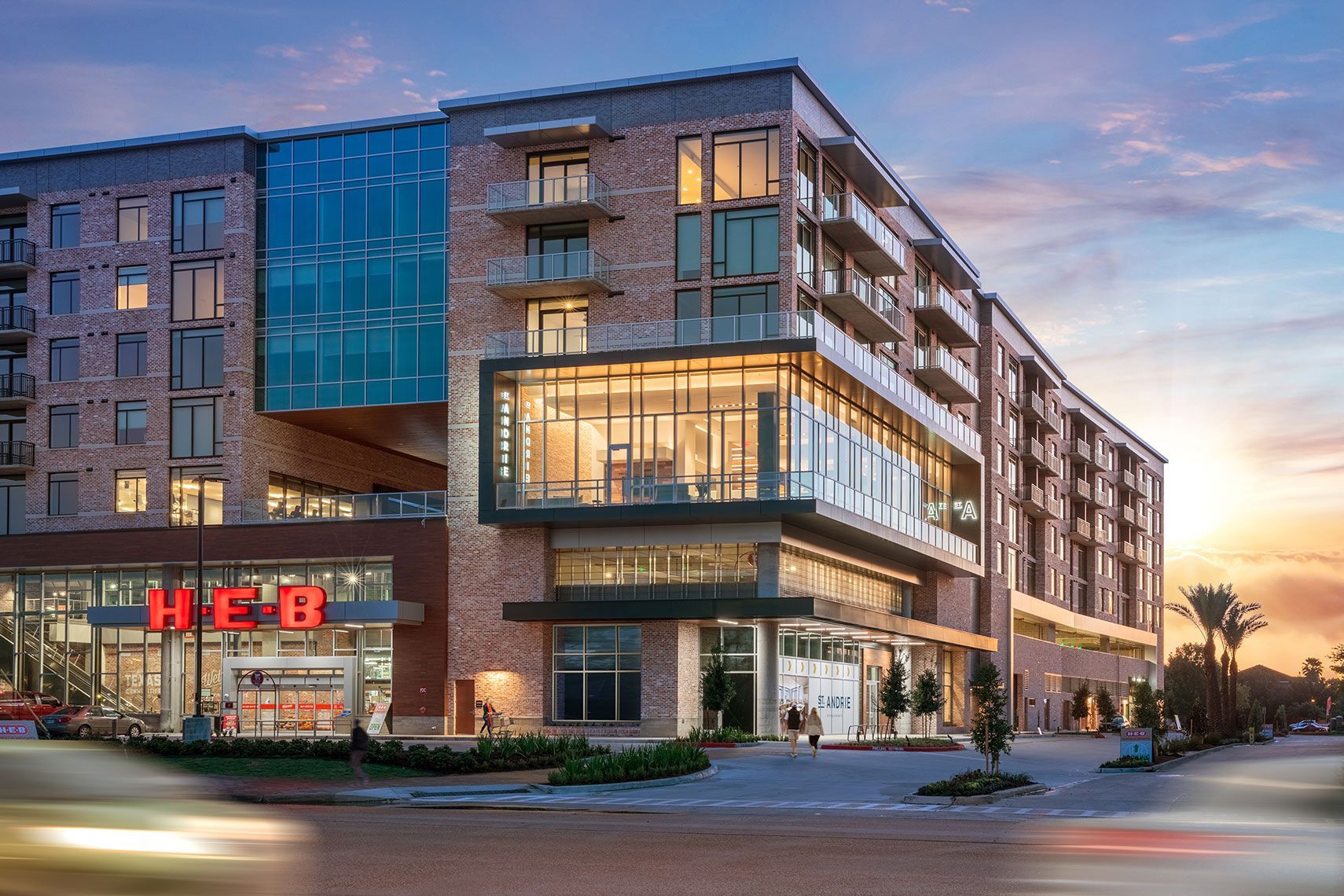 A large building with a h-e-b store in the middle of it.