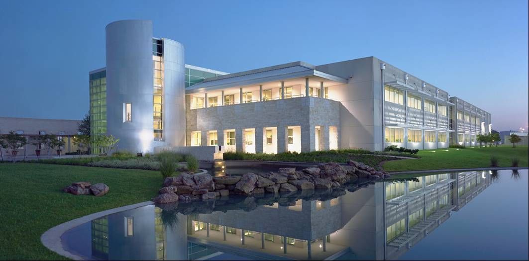 A large white building is sitting next to a body of water.