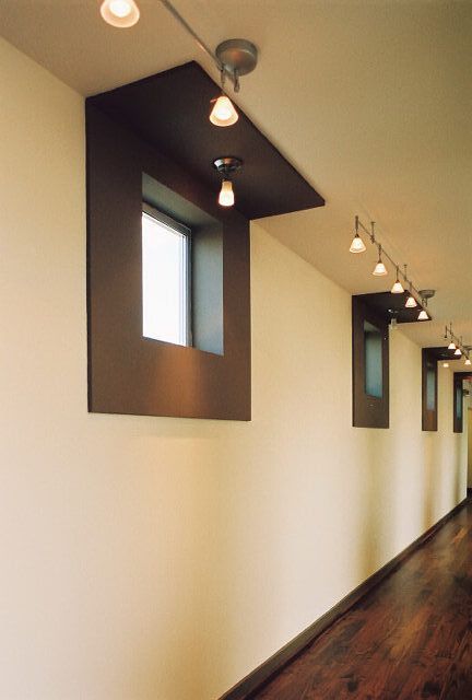 A long hallway with a row of windows and lights on the ceiling