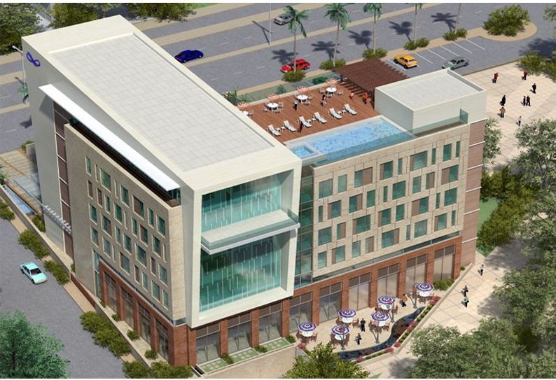 An aerial view of a large building with a pool on top