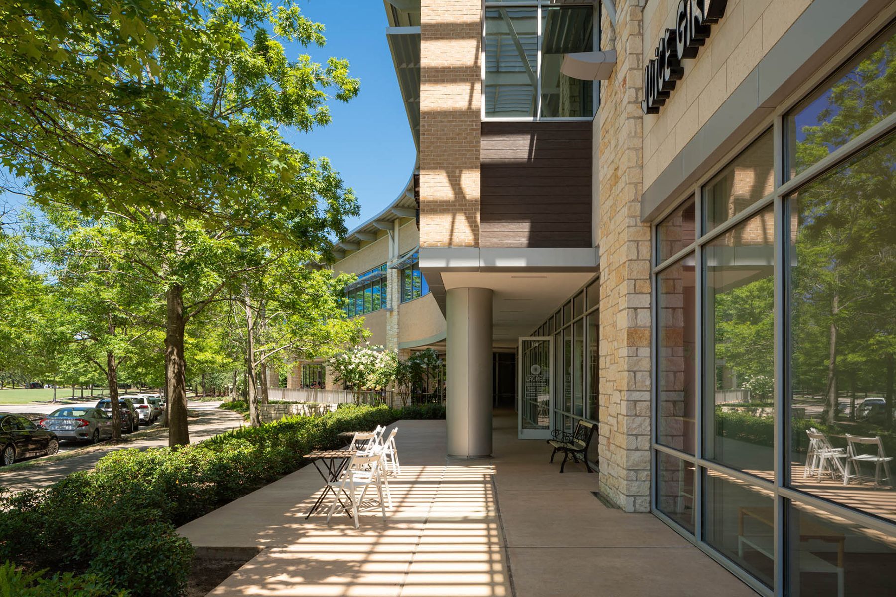A large building with a lot of windows and trees in front of it