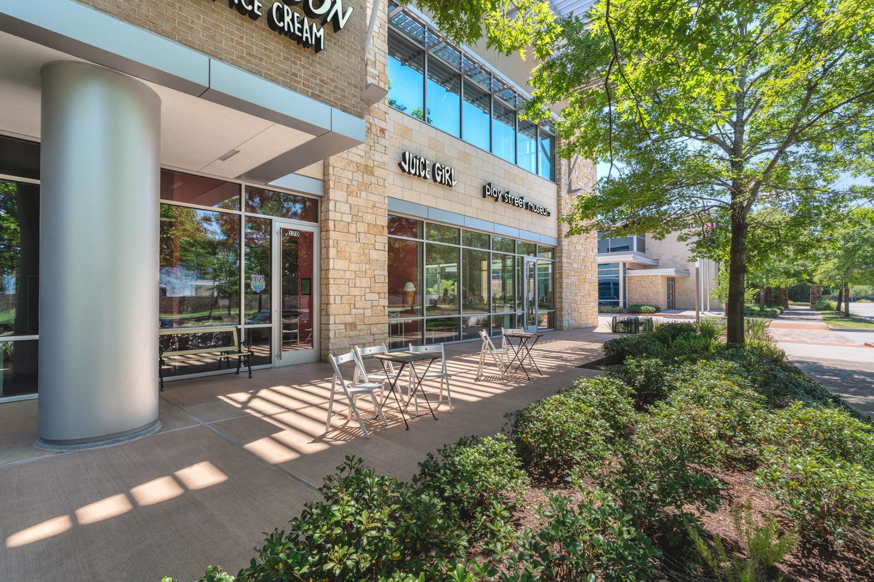 A large building with a patio area in front of it.