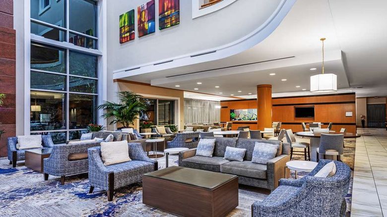 A hotel lobby with a couch , chairs , and tables.
