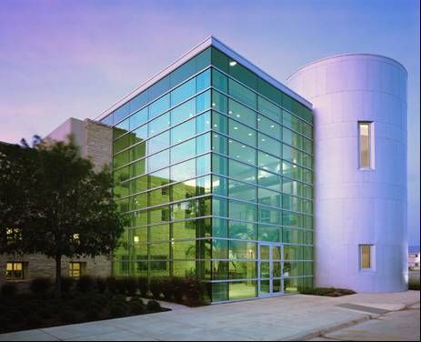 A building with a lot of windows and a purple sky in the background