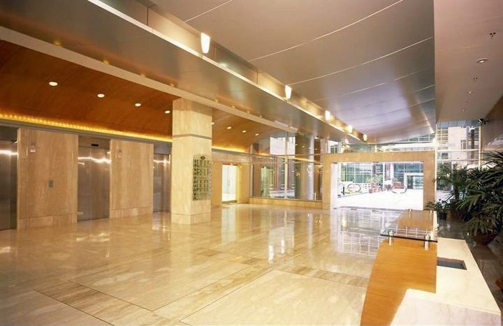 A large empty lobby with elevators and a table.