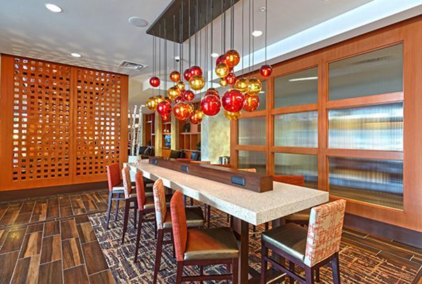 A long table with chairs in a room with a chandelier hanging from the ceiling.
