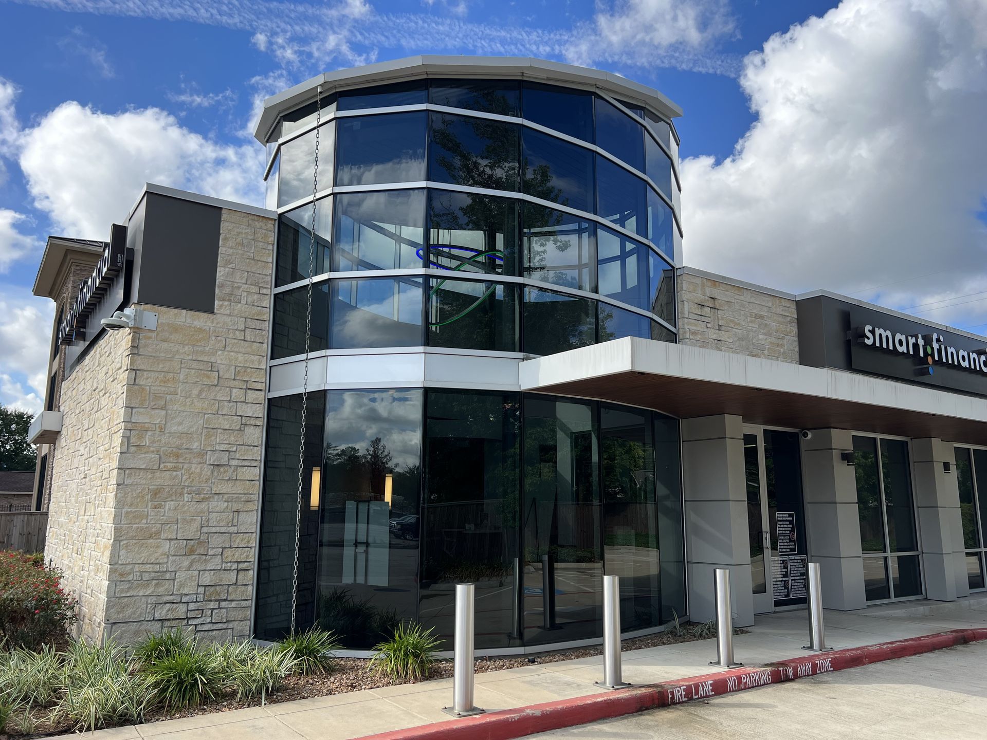A large building with a lot of windows and a red curb.