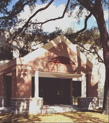A brick building with a tree in front of it