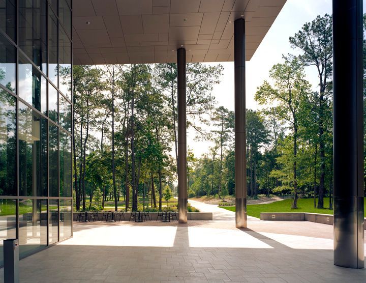 A building with a covered walkway and trees in the background