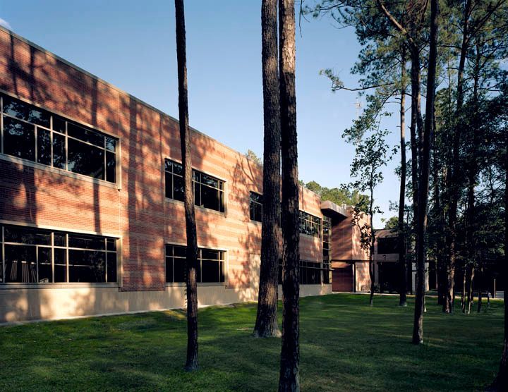 A large brick building surrounded by trees and grass