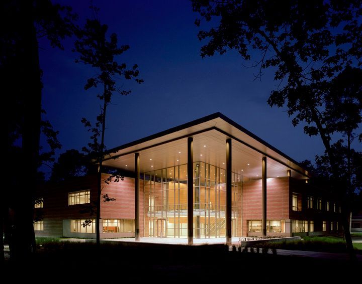 A large building with a lot of windows is lit up at night