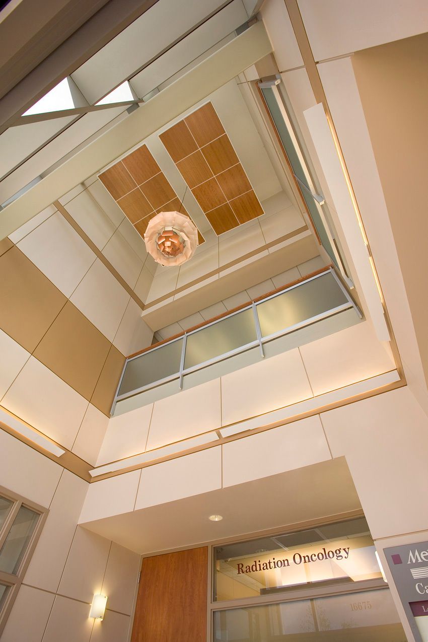 Looking up at the ceiling of a building with a balcony.