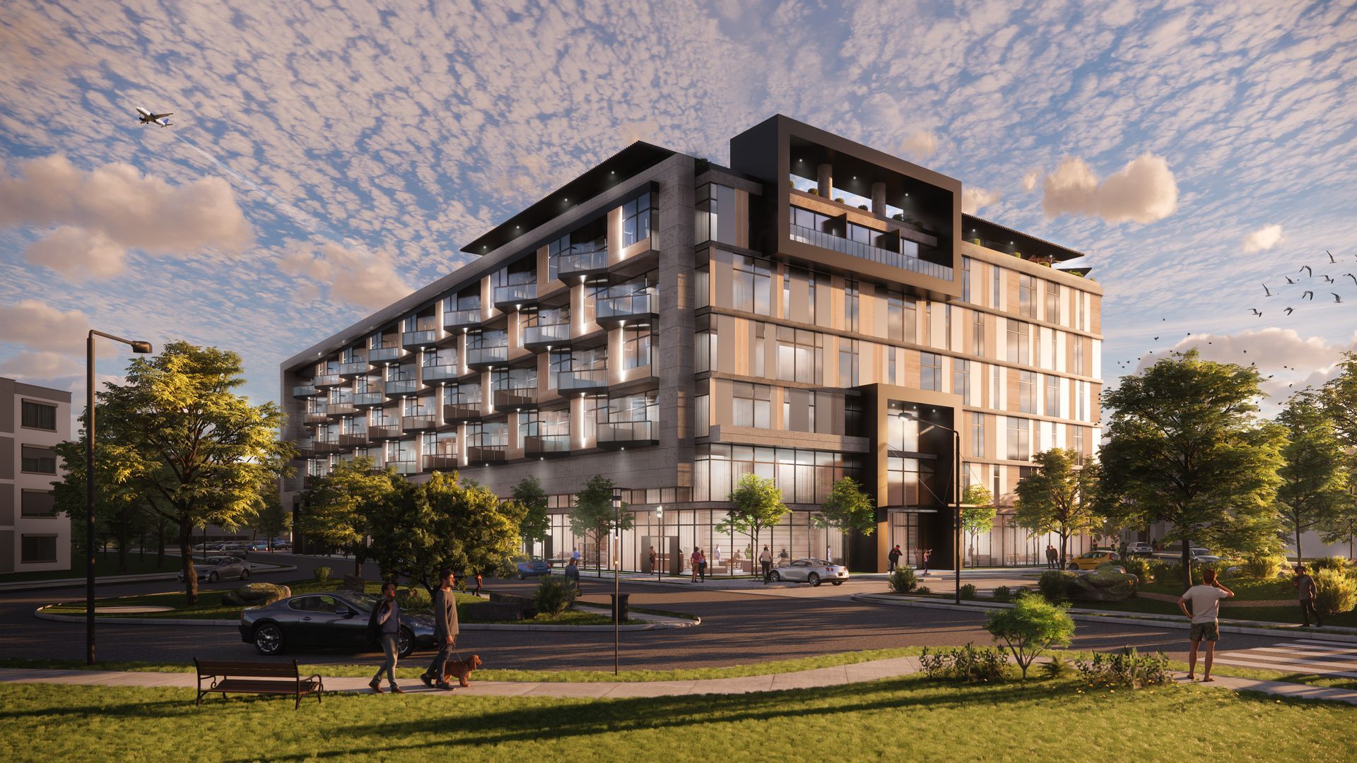 A large building with a lot of windows is surrounded by trees and grass.