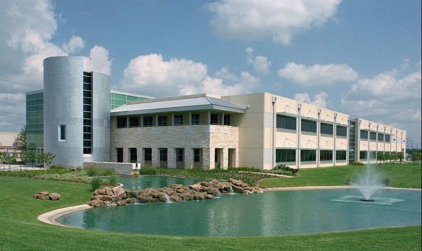 A large building with a pond in front of it