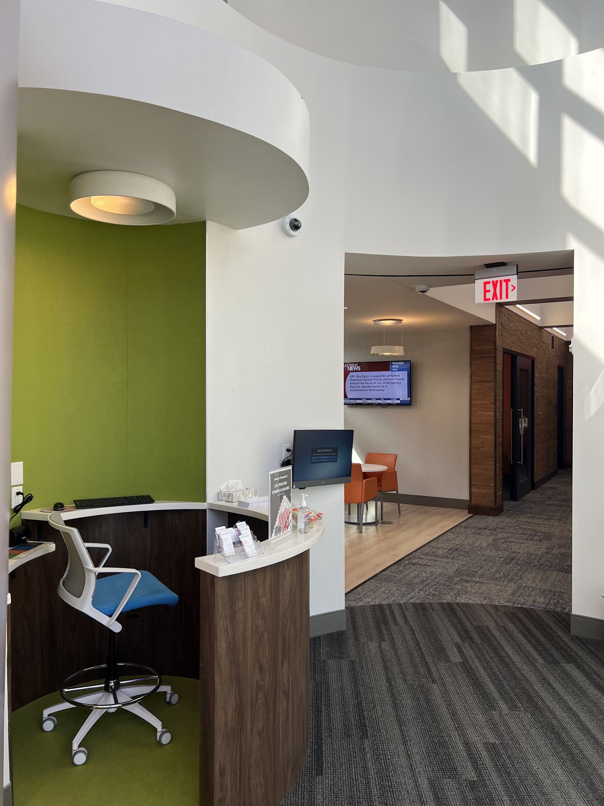 A dental office with a desk and chair and an exit sign