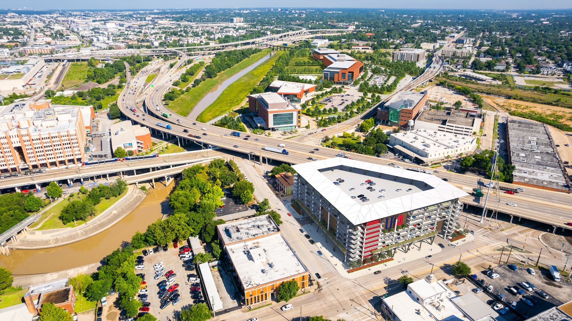 An aerial view of a city with a large building in the middle of it.