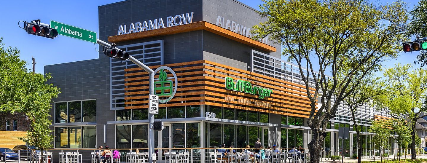 A large building with a lot of windows and trees in front of it.