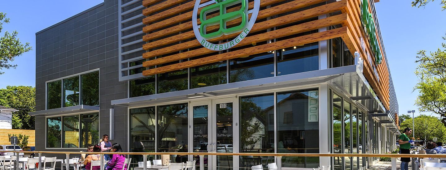 A large building with a lot of windows and people standing outside of it.