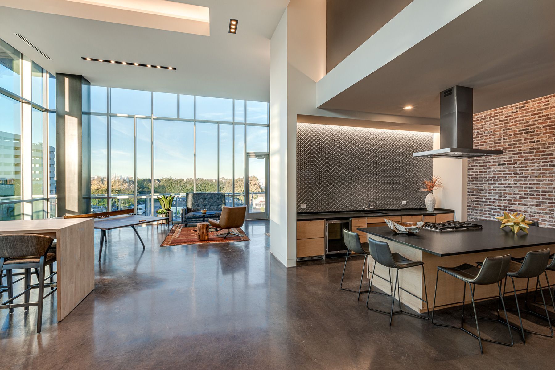 A large room with a lot of windows and a kitchen.