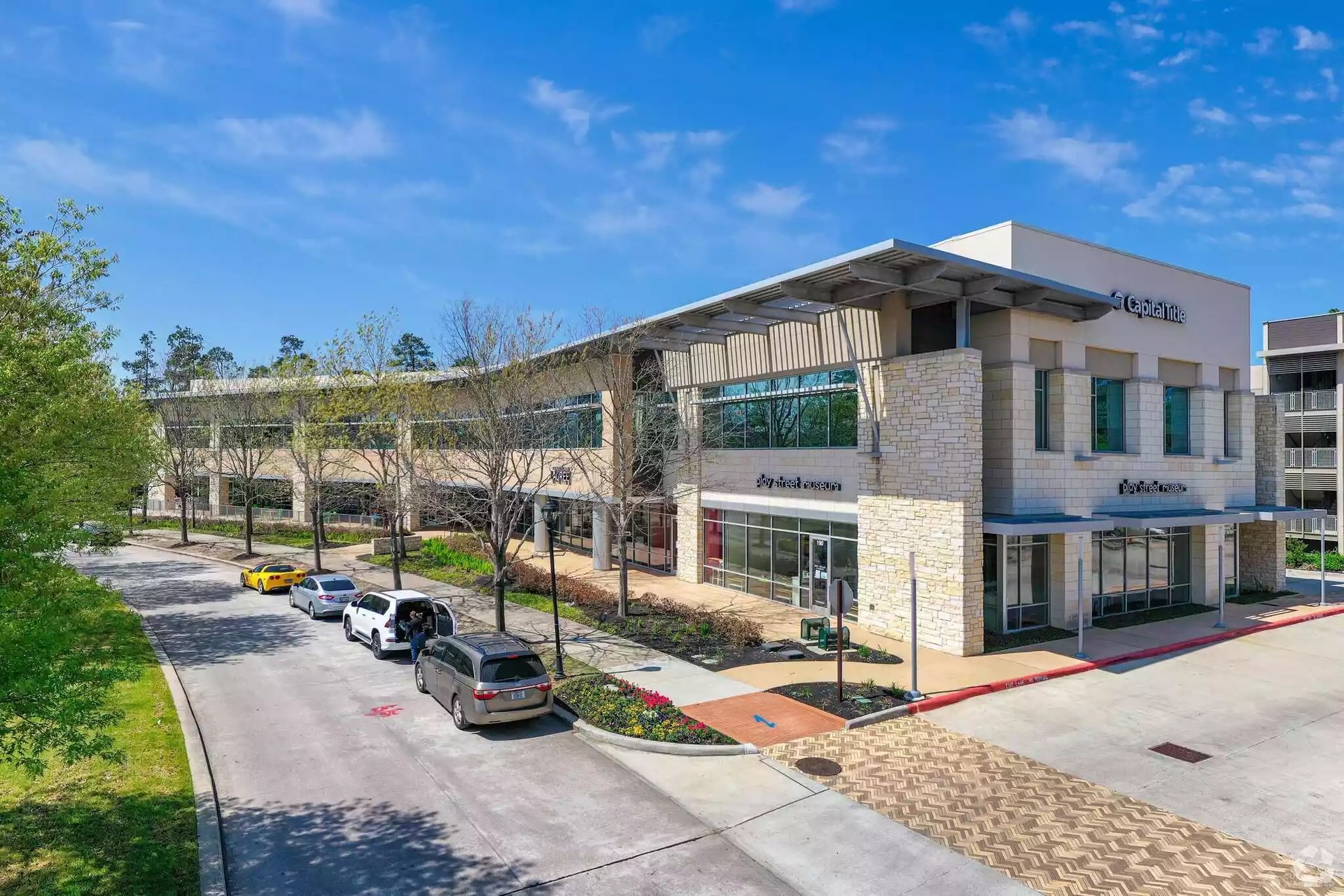 An aerial view of a large building with cars parked in front of it.