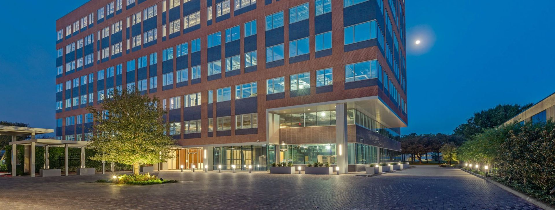 A large brick building with a lot of windows is lit up at night.