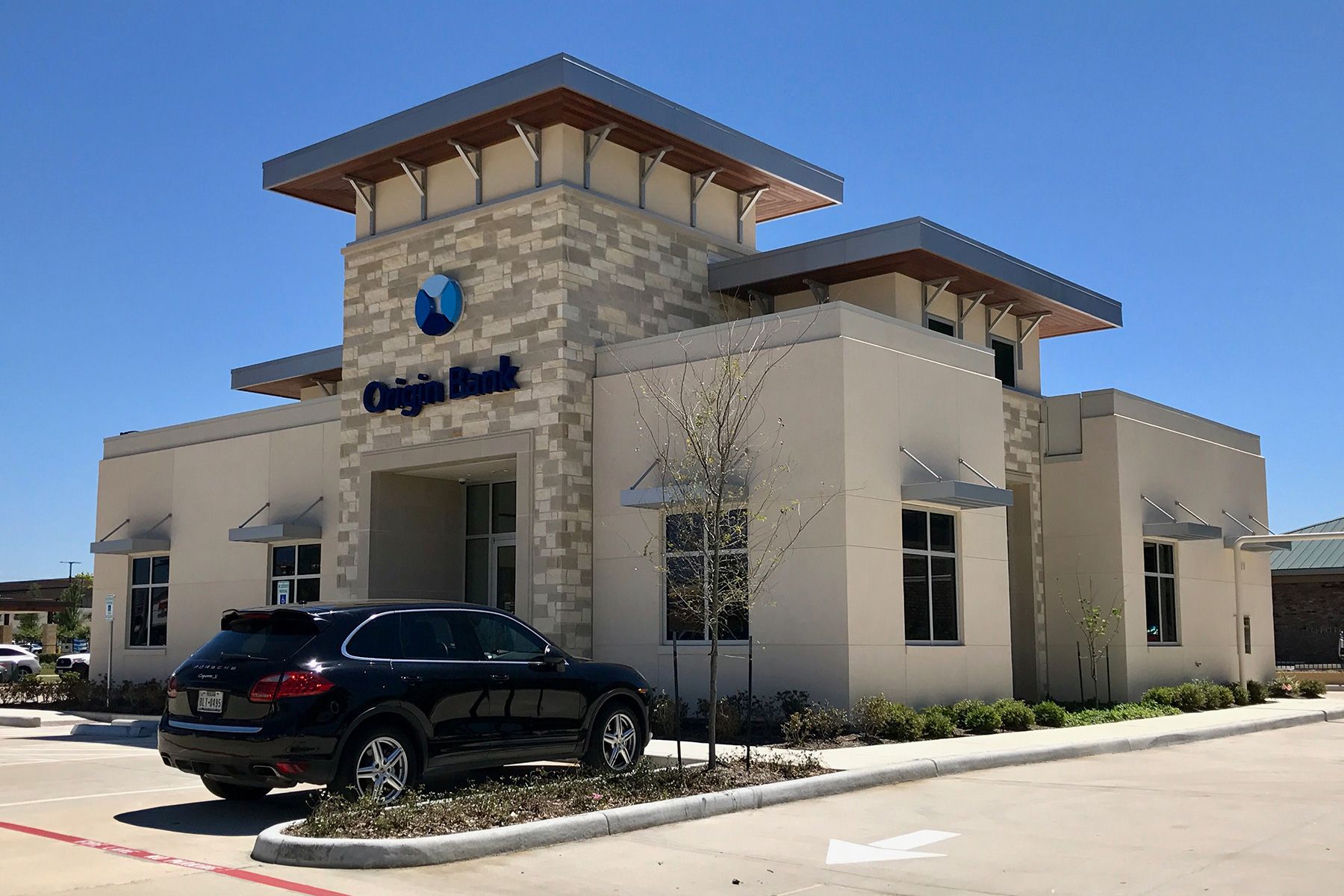A car is parked in front of a bank building.