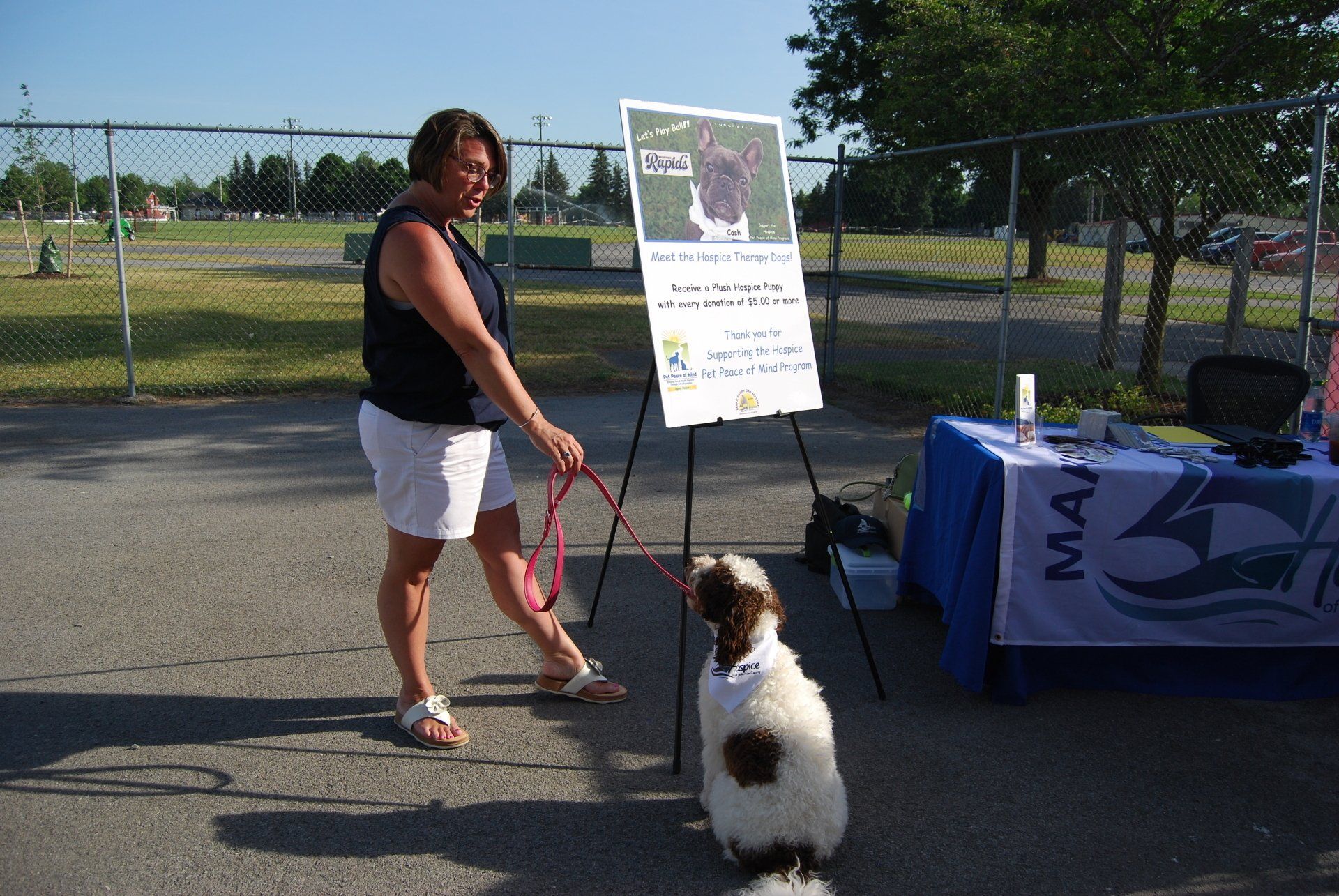 A woman walking a dog on a leash in front of a sign that says man