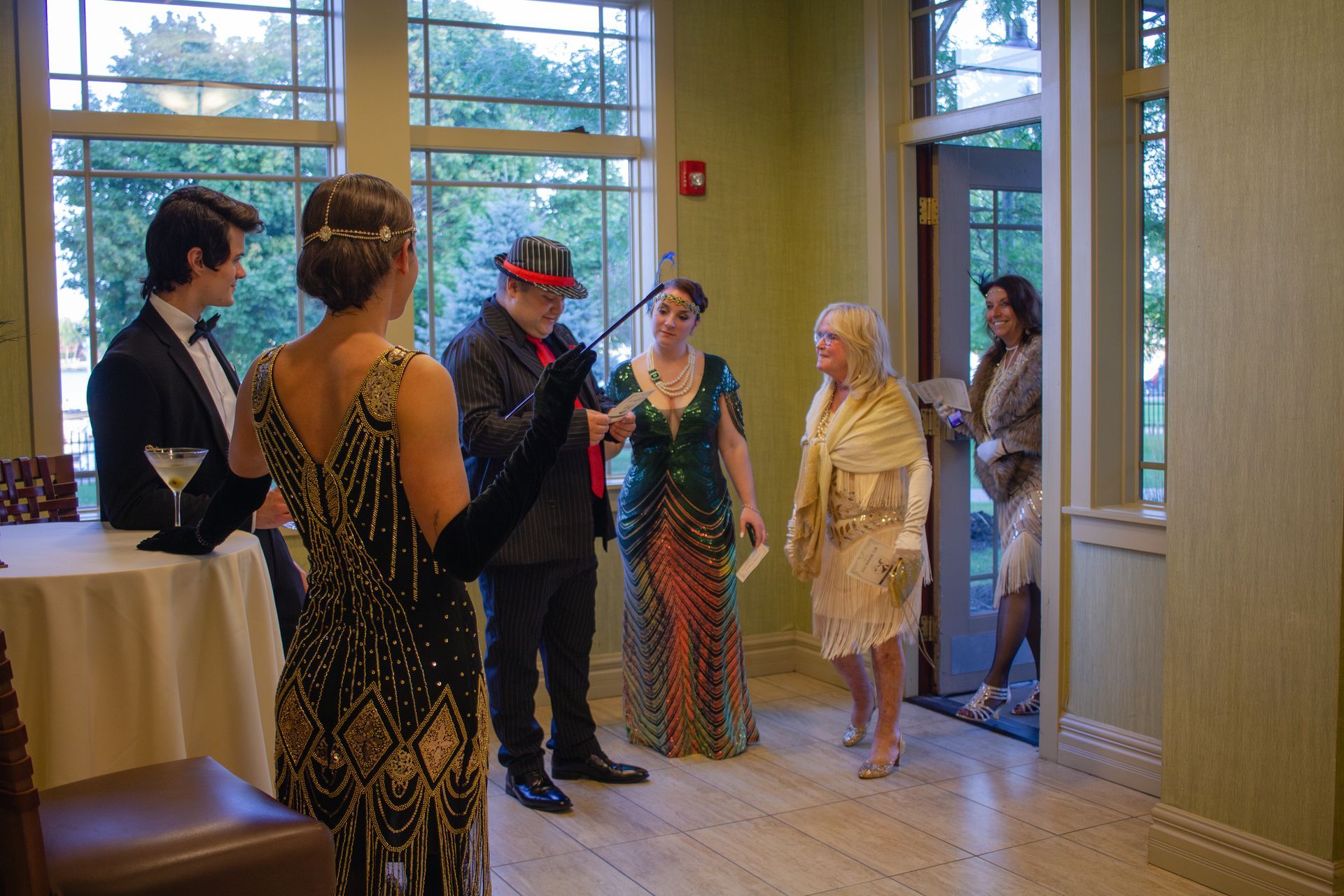 A group of people dressed in flapper costumes are standing in a room.