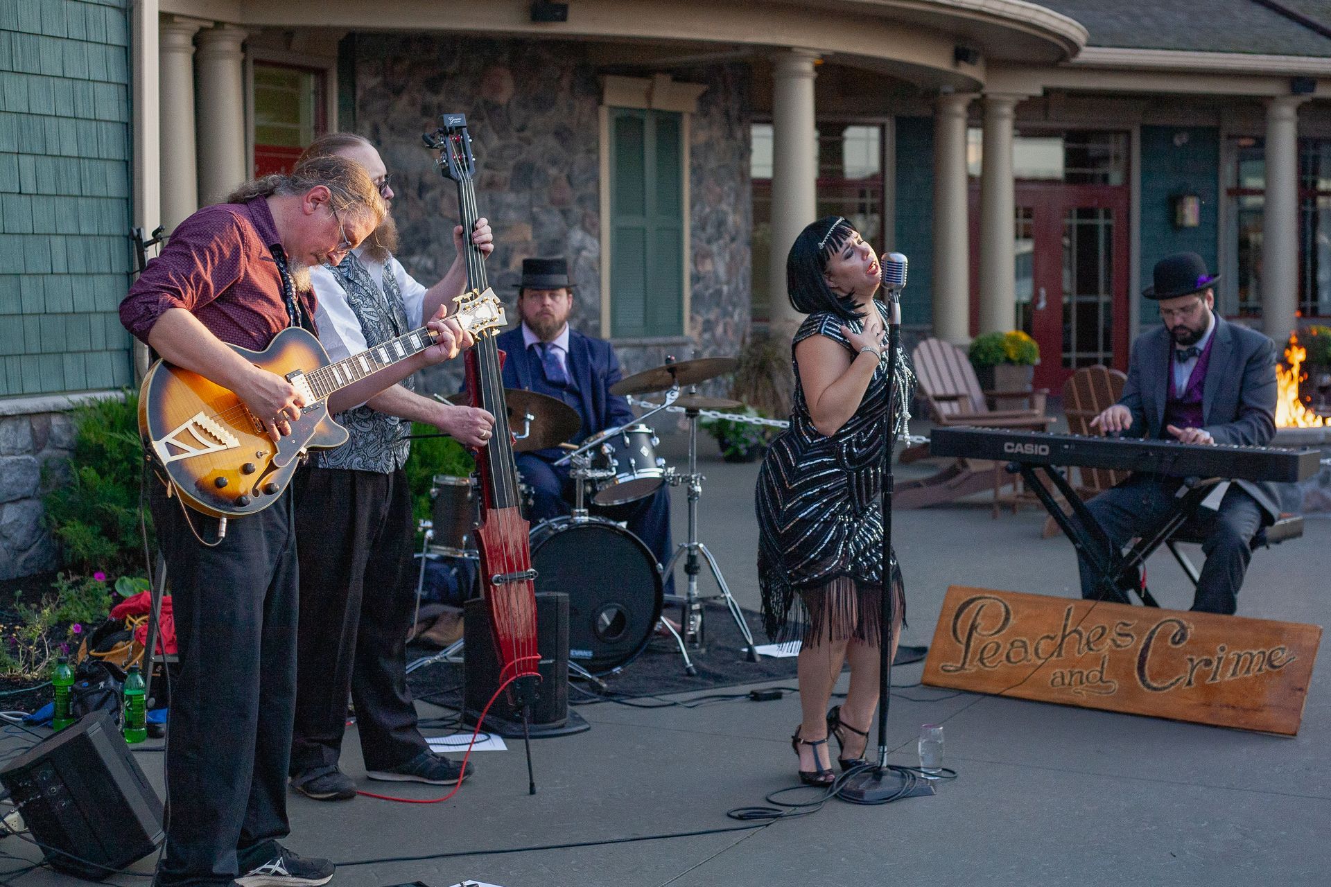 A woman is singing into a microphone while a group of people play instruments.