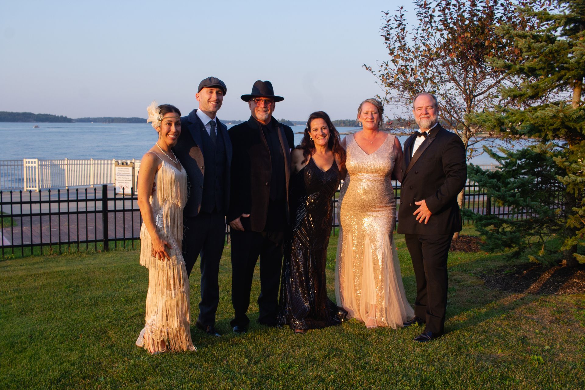 A group of people posing for a picture in front of a body of water