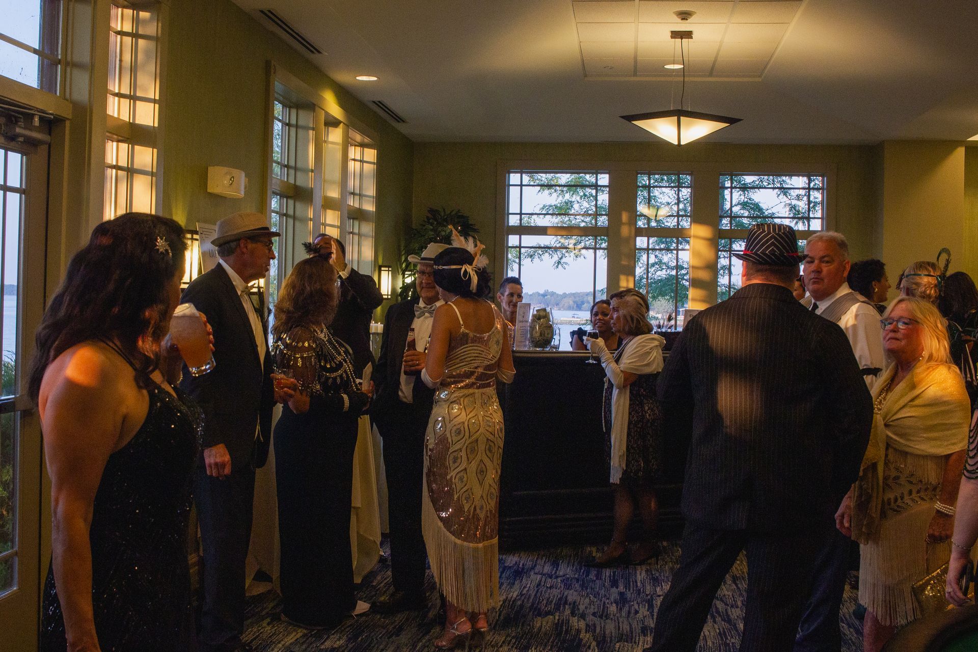 A group of people are standing in a room talking to each other